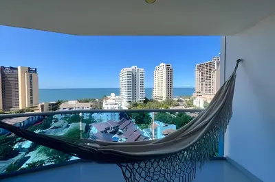 a hammock on a balcony with a view of a city at Exclusivo apartamento vista al mar in Santa Marta