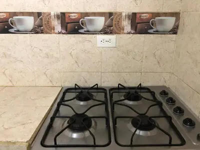 a stove top in a kitchen with two cups on a counter at Entire apartment bathroom AC Smart tv wifi kitchen in Barranquilla