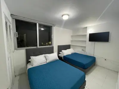 a small room with two beds and a television at expetacular apartamento de 4 alcobas in Cartagena de Indias