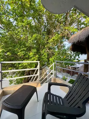 a patio with two black chairs and an umbrella at Orilla beach house in Playa Punta Arena