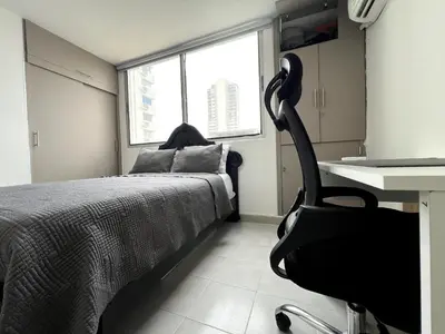 a bedroom with a bed and a desk and a chair at 1401 Apartamento con AC, Piscina y Cerca Playa in Cartagena de Indias