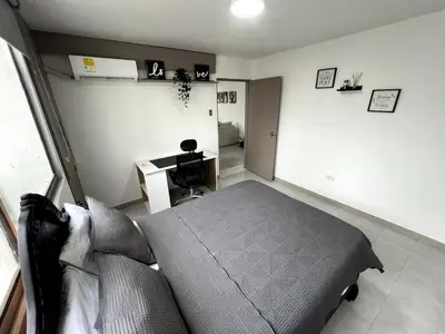 a bedroom with a bed and a desk at 1401 Apartamento con AC, Piscina y Cerca Playa in Cartagena de Indias