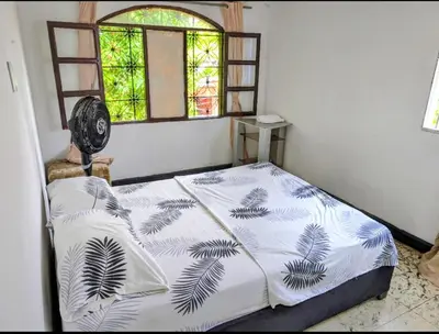 a bedroom with a bed with a fan and a window at Central Point Air BAQ in Barranquilla