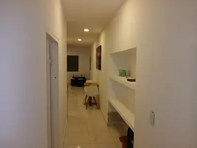 a hallway with a white wall and a room with a table at Apartasuite Marbella in Cartagena de Indias