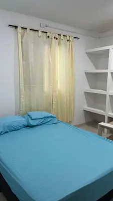 a bedroom with a blue bed and a window at Apartamento Yulenis Coveñas in Guayabal