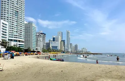 a beach with people in the water and buildings at Apartaestudio Económico en Cartagena, al lado de la Playa in Cartagena de Indias