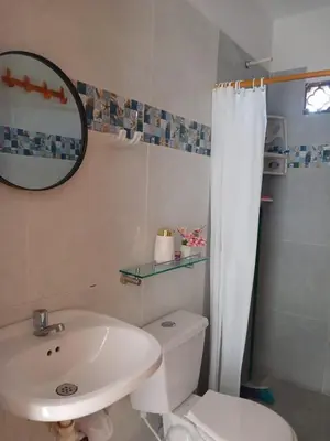 a bathroom with a sink and a toilet and a mirror at Mararena in Coveñas