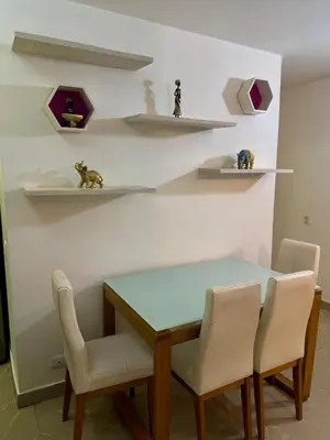 a dining room with a table and chairs and shelves at Apartamento moderno in Cartagena de Indias