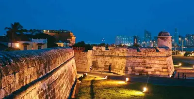 a wall with a city in the background at night at Hermoso apartamento loft en la ciudad amurallada de cartagena 1 in Cartagena de Indias