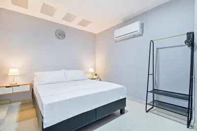 a white bedroom with a bed and a mirror at Beautiful House 3 minutes from Historic Downtown in Cartagena de Indias