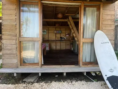 a house with two surfboards standing outside of it at CARPE DIEM oceanfront cabin private beach in San Bernardo del Viento