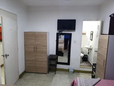 a bedroom with a mirror and a tv on the wall at Hostal Mastcoy in Cartagena de Indias