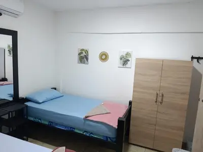 a small bedroom with a bed and a cabinet at Hostal Mastcoy in Cartagena de Indias