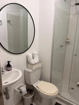 a bathroom with a toilet and a sink and a mirror at Brand new apartment near the beach and historic center in Cartagena de Indias