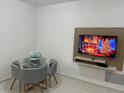a dining room with a table and a flat screen tv at Brand new apartment near the beach and historic center in Cartagena de Indias