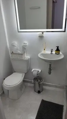 a white bathroom with a toilet and a sink at Brand new apartment near the beach and historic center in Cartagena de Indias
