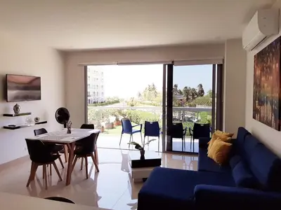 a living room with a blue couch and a table and chairs at APARTAMENTO MORROS EOS y ECO VISTA AL MAR in Cartagena de Indias