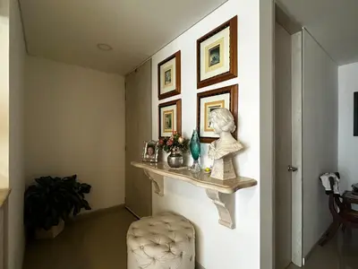 a hallway with a shelf and a statue on a wall at Lujoso apartamento frente al Castillo de San Felipe in Cartagena de Indias