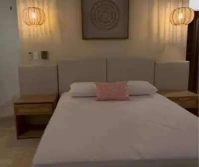 a large white bed with a pink pillow on it at Casa Azure Playas del Francés in El Puertón