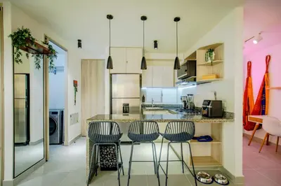 a kitchen with a bar with three stools at Aguita de coco in Cartagena de Indias