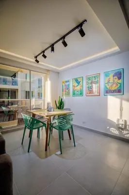 a dining room with a table and green chairs at Aguita de coco in Cartagena de Indias