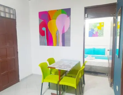 a dining room with a table and chairs and a painting at tranquilo alojamiento centro cartagena in Cartagena de Indias