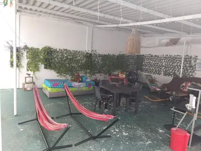 a living room with a table and hammocks in it at Hostal Mastcoy in Cartagena de Indias