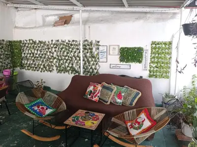 a living room with a couch and chairs with pillows at Hostal Mastcoy in Cartagena de Indias