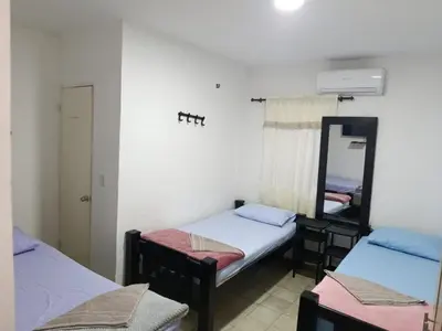 a room with two beds and a mirror at Hostal Mastcoy in Cartagena de Indias