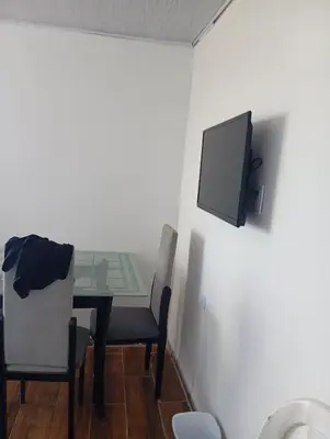 a dining room with a table and a tv on the wall at Casa vista al mar in Puerto Colombia