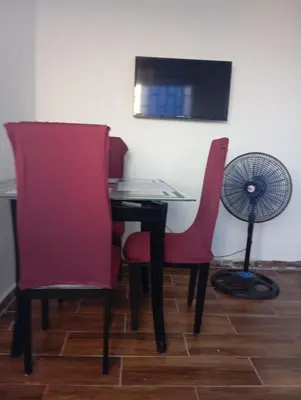 a table and two chairs with a fan and a desk at Casa vista al mar in Puerto Colombia