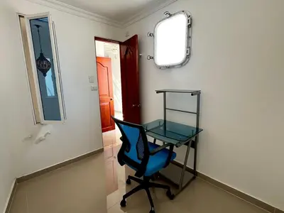 a blue chair and a glass table in a room at Beautiful Furnished House in CTG in Cartagena de Indias