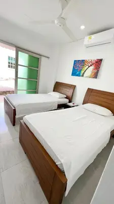 a bedroom with two beds and a painting on the wall at Hotel Zoe in Sampués