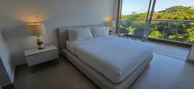 a bedroom with a white bed and a large window at Baia Kristal Cartagena Kabo 2-3N in Los Arrayanes