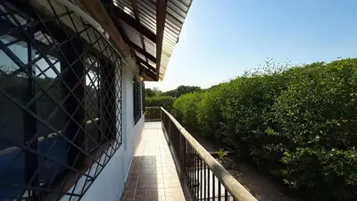 a balcony of a house with a fence and trees at Cabaña Punta Helvetica in San Antero
