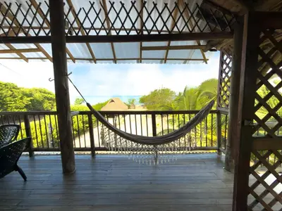 a hammock on the porch of a house at Cabaña Punta Helvetica in San Antero