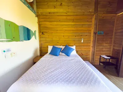 a bedroom with a bed with blue pillows at Cabaña Punta Helvetica in San Antero