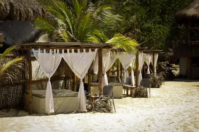 a line of beds on a beach with trees at Cabaña privada con Jacuzzi a solo un minuto de la playa in Isla de Tierra Bomba