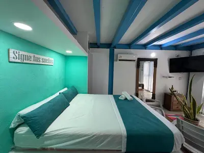 a bedroom with a large bed with a green wall at Cabaña privada con Jacuzzi a solo un minuto de la playa in Isla de Tierra Bomba