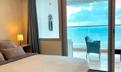 a bedroom with a bed and a view of the ocean at Apartasuit Resort CTG Beach con vista al mar- central 5 min aeropuerto in Cartagena de Indias