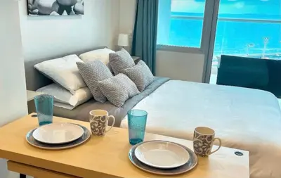 a room with a bed and a table with plates on it at Apartasuit Resort CTG Beach con vista al mar- central 5 min aeropuerto in Cartagena de Indias