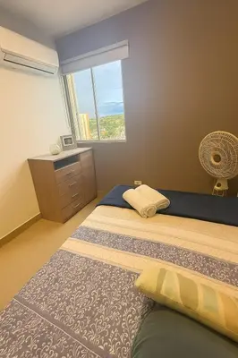 a bedroom with two beds and a window at Oasis Costero Apartment in Cartagena de Indias