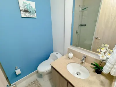 a bathroom with a white toilet and a sink at Lujoso apartamento para estrenar Terraz - Playa Dormida in Santa Marta