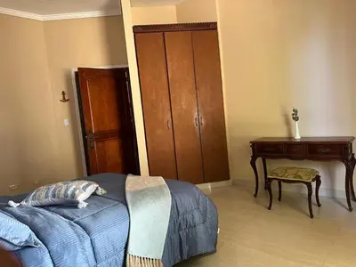 a bedroom with a bed and a wooden cabinet at Mansión Lujosa con Piscina en manga in Cartagena de Indias