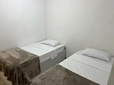 two beds in a room with white walls at Cartagena Visible Hostal in Cartagena de Indias