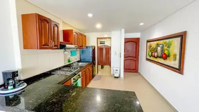 a kitchen with wooden cabinets and a black counter top at Excepcional apartamento Cartagena in Cartagena de Indias