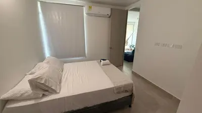 a bedroom with a bed in a white room at apartment near the beach con piscina, gym y coworking in Manzanillo del Mar