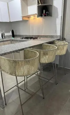 a kitchen with four chairs and a counter at apartment near the beach con piscina, gym y coworking in Manzanillo del Mar