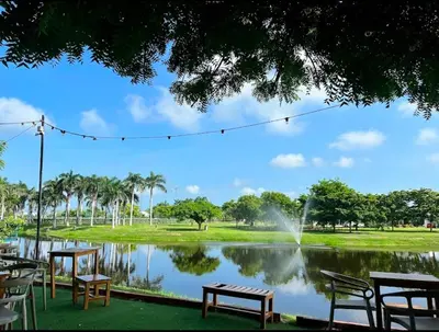 a park with a pond with chairs and a fountain at apartment near the beach con piscina, gym y coworking in Manzanillo del Mar