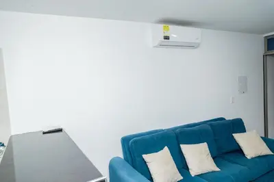 a blue couch in a living room with a laptop at Apartamentos King Arthur in Punta Seca